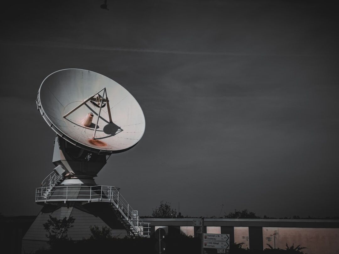 Technician adjusting a satellite dish on a broadcast van