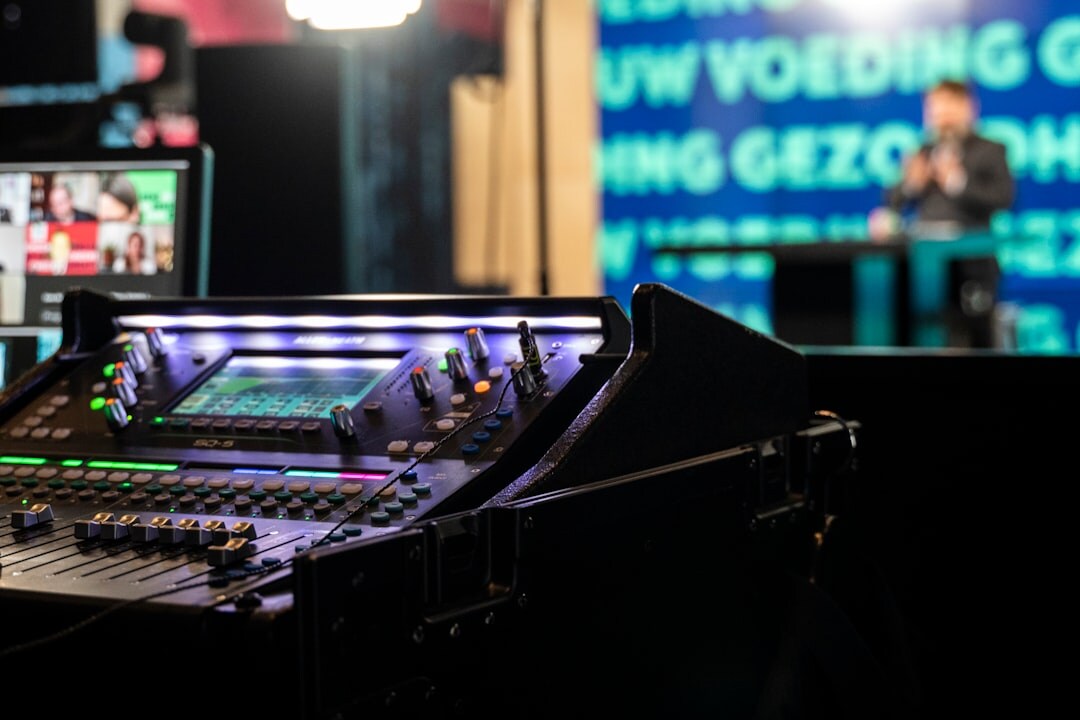 Team of broadcast trainers gathered around a video routing console
